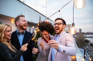 group of young adults with sparklers on a rooftop bar