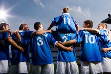 Soccer team celebrating with boy on shoulders